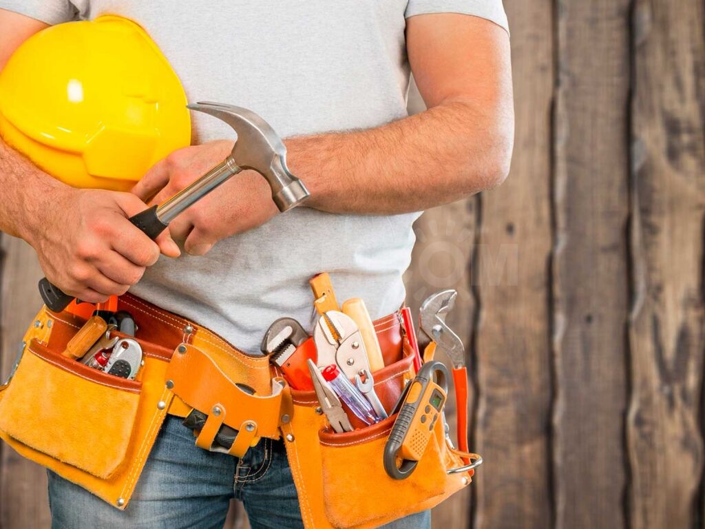 A man holding a hammer and some tools