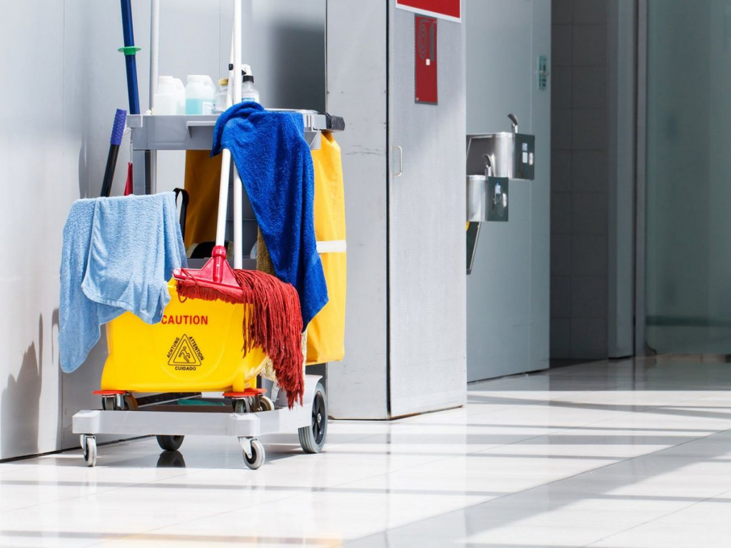 A cleaning cart with some clothes on it