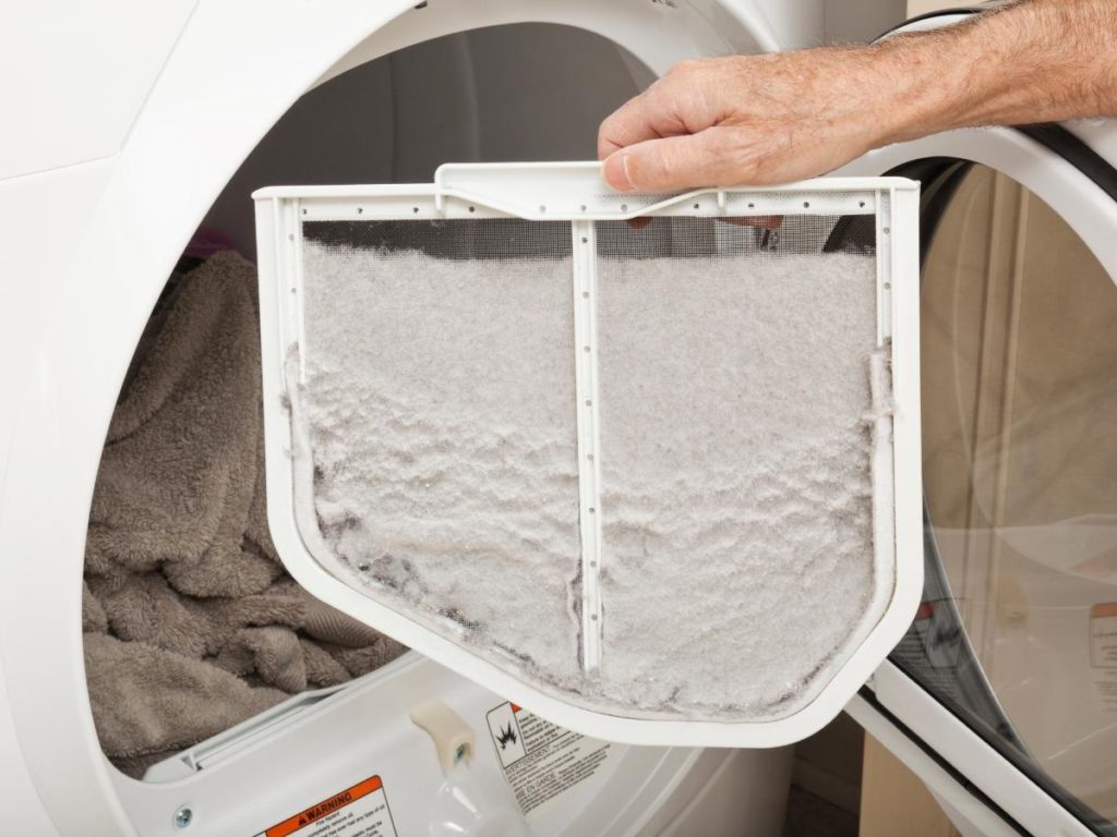 A person holding an air filter in front of the dryer.