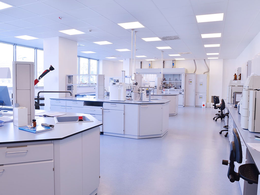 A clean lab with many white counters and tables.