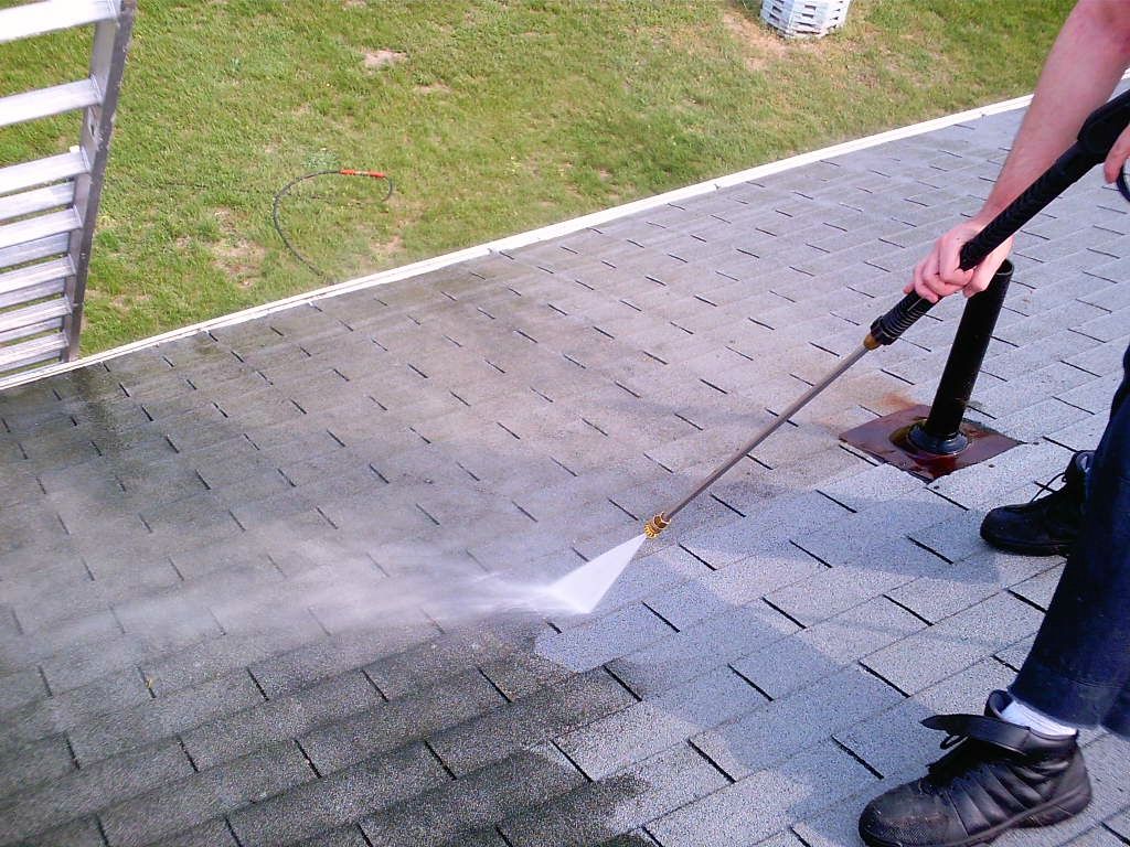 A person is cleaning the roof of a house.