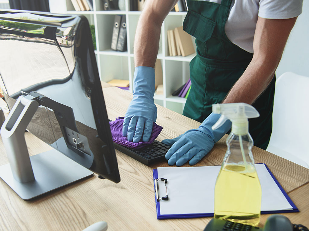 A person cleaning the keyboard of a laptop.